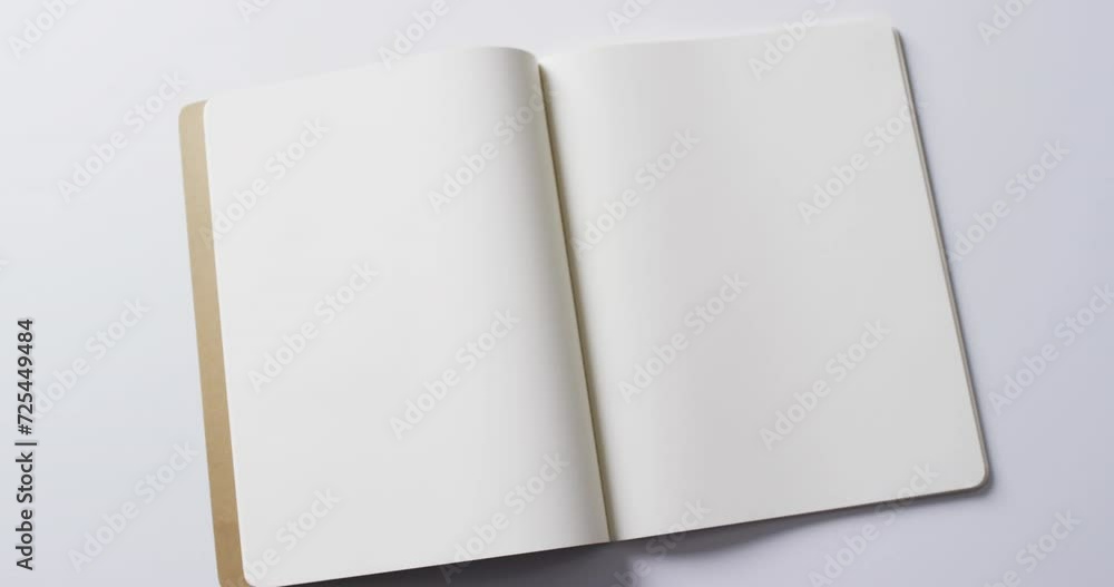 Poster close up of open blank book with copy space on white background in slow motion