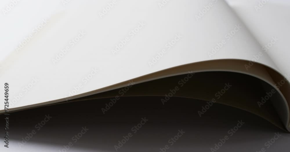 Poster close up of open blank book with copy space on white background in slow motion