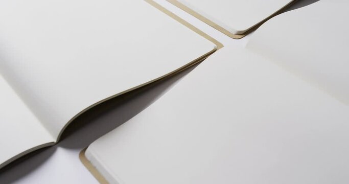 Close up of open blank books with copy space on white background in slow motion