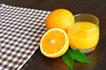 glass of orange juice with orange fruit on dark table copy space