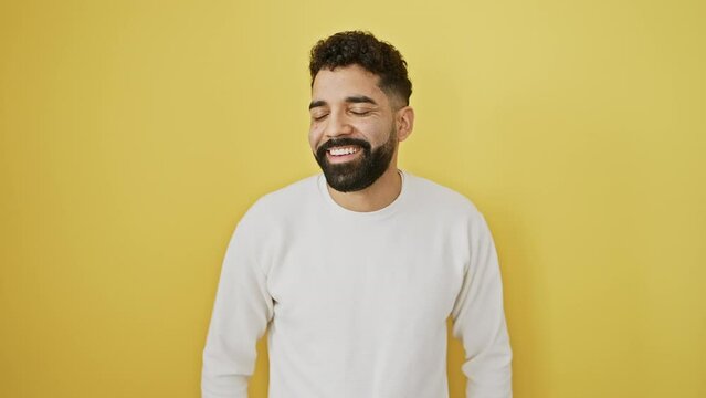 Confident young man stands away, side profile flashing a natural, happy smile and infectious laugh. isolated on a vibrant yellow background.
