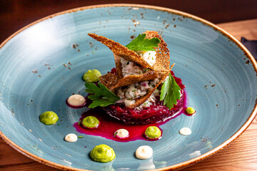 salad with beetroot, greens and sauce on a blue plate