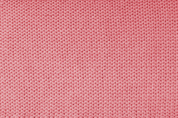 Close up background of knitted wool fabric made of viscose yarn, red color wool knitwear texture. Sweater, pullover knitted jersey background. Fabric abstract backdrop, wallpaper
