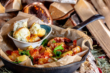 Fried shrimp with baked meat with vegetables and cheese in a pan on the table