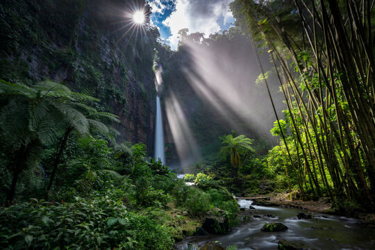 Sunburst and sunbeams over Kapas Biru Waterfall (Coban Kapas Biru), Lumajang, East Java, Indonesia
