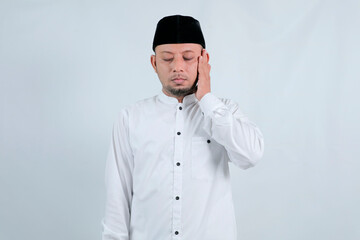 Man in a white shirt and black cap praying.