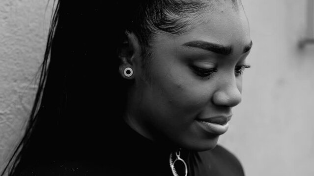 One sad lonely black teenage girl in deep mental reflection looking down in worry and angst, self-judgemental adolescent girl in thoughtful inner turmoil