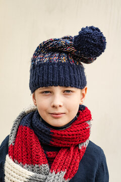 Portrait of a young boy wearing a woolly bobble hat and scarf