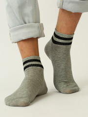gray socks with black stripes on human foot close up photo on white background