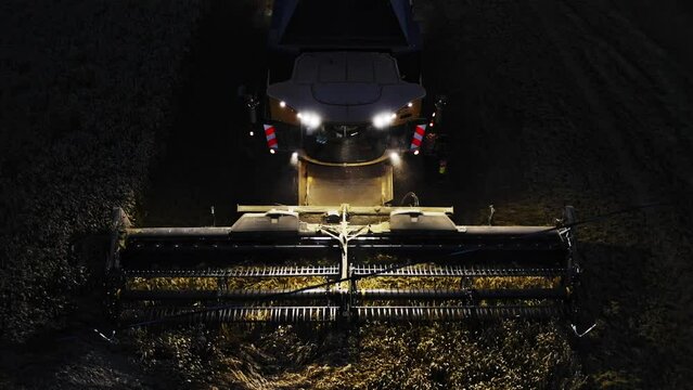 Combine harvester working at night with lights on