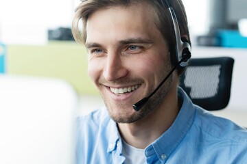 Dedicated service creates dedicated customers. Shot of a young man using a headset and computer in...