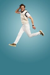 Fototapeta na wymiar Full length body size view of attractive cheerful active guy jumping running isolated over blue color background.