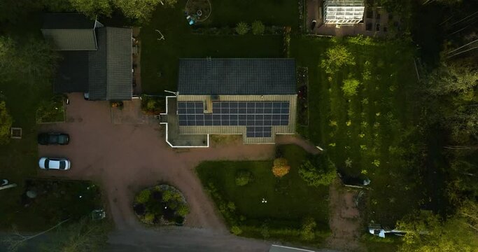 Aerial view of Photovoltaic cells generating electricity on a private house roof, fall sunset