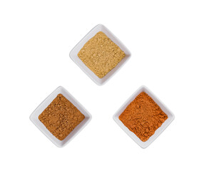 Various Indian Spices in Small White Bowls on white background