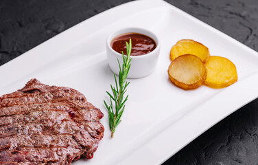 big juicy steak with potatoes on plate