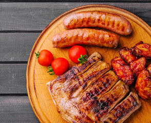 pork ribs with chicken and sausages on wooden board