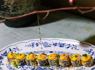 warm sushi maki rolls with cheese sauce sprinkled with soy sauce © AntAlexStudio