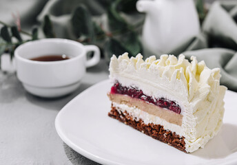 Layered Mousse Cake on white plate and cup of tea