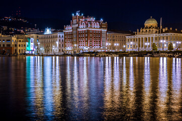 Obraz premium Dusk and night in Trieste. Between historic buildings and the sea.