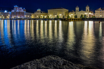 Fototapeta na wymiar Dusk and night in Trieste. Between historic buildings and the sea.