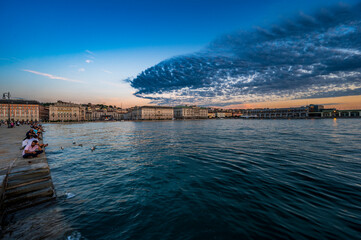 Dusk and night in Trieste. Between historic buildings and the sea. - 725478665