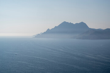 Blick auf die dunstige Küstenlandschaft um das Naturschutzgebiet Scandola, Golf von Porto, Korsika, Frankreich