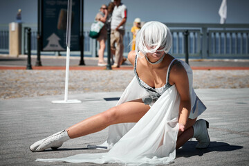 Young sexy girl in space silver micro skirt dancing with white silk scarf waving gracefully, female...
