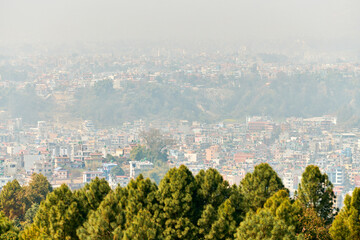View of Kathmandu capital of Nepal from mountain through urban haze with lot of low rise buildings, cityscape creating an ethereal atmosphere in mountain air, Kathmandu air pollution