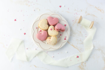 French sweet cookies macarons macaroon with color sprinkles on retro plate on marble table...