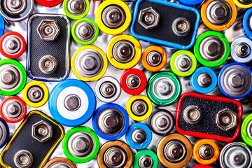 Energy abstract background of colorful batteries.Old used batteries ready for recycling.Used batteries from different manufacturers, waste, collection and recycling,Alkaline battery aa size.