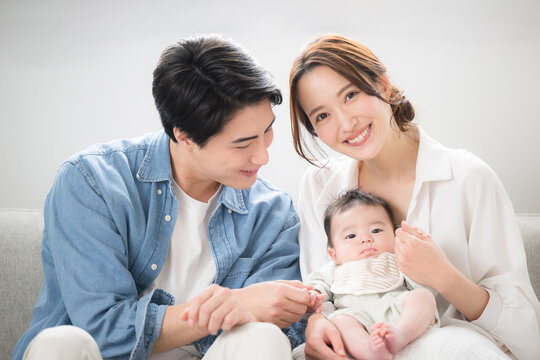 Young family, dad and mom holding baby Image of a happy family in a clean room