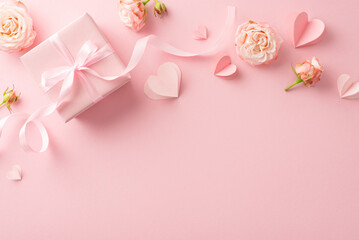 Shower your glam queen with love! Top view capture of radiant peony roses, heart symbols, and an elegantly packaged gift on a serene pastel pink background. Ideal for your Women's Day dedication