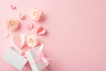Shower your glamorous girlfriend with love! Top view shot of an open giftbox surrounded by blooming rosebuds, hearts on a pastel pink surface. Perfect for heartfelt messages or promotions