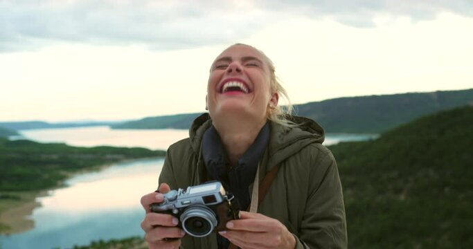 Camera, photograph and happy woman in nature for a hiking adventure on holiday in Norway. Excited, vintage photography and laughing female person outside in Europe for vacation getaway with memories