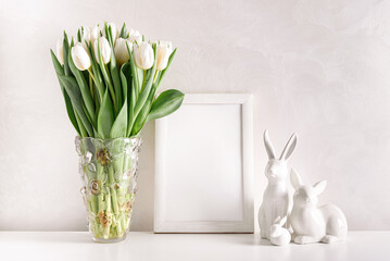 Blank wooden border with Easter rabbits figurines and bouquet of white tulips on white background....