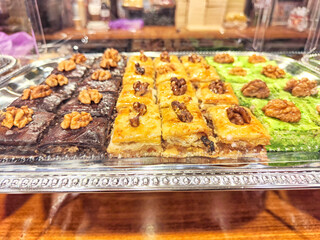 Various types or many colorful assortment of Turkish sweets for sale in shop food festival. Baklava and pastries are sold on trays on the counter. Travel, Ramadan