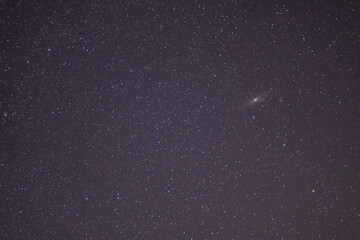The Andromeda Galaxy in the night sky. Dark place with shining stars in summer