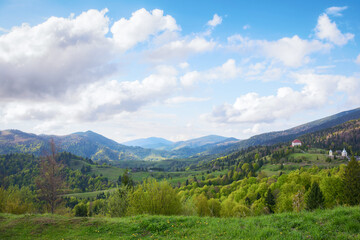 natural beauty of the ukrainian mountainous rural landscape in spring. alpine countryside scenery with grassy rolling hills in evening light. mountain ridge in the distance beneath a sky with clouds