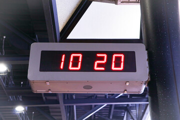 Digital clock time LED red number on black digital electric Brown wooden border stuck hanging on concrete pole. Time symbol concept for celebrating the New Year. At Time 10.20 AM.