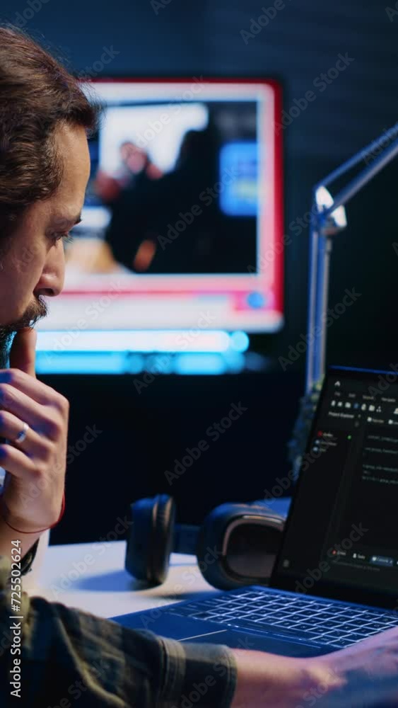 Poster vertical video experienced programmer writes code on laptop screen while in apartment office using j