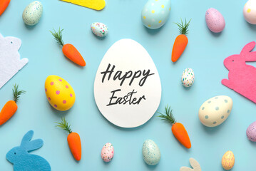 Happy Easter. Composition with colorful easter eggs,easter bunnies and carrots with a white egg in the center with text Happy Easter
