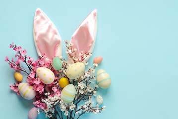 Happy Easter. Colorful easter painted eggs on bunny ears and pink and white almond blossoms with...