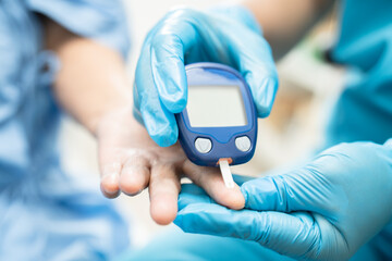 Doctor check diabetes from finger blood sugar level with finger lancet.