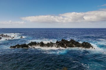Waves flow over weathered rocks.
