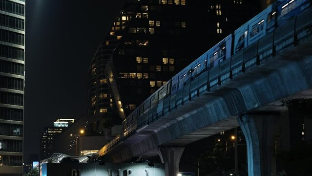 Train in modern night city on background of buildings, subway bts skytrain bangkok thailand
