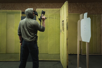 Tactical shooting from modern firearms with night vision at a shooting range, close-up photo. A man...