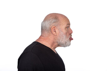Obraz premium Profile Portrait, Middle-Aged Bearded Man in Black T-Shirt Sticking Out Tongue - Playful Humor on White Background