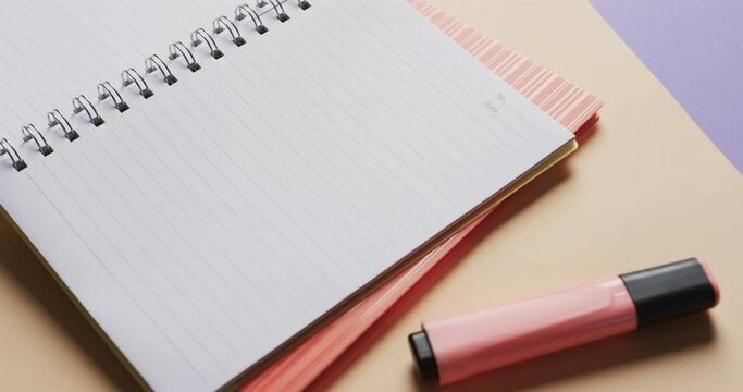 Close up of open notebook with school stationery on beige and blue background, in slow motion