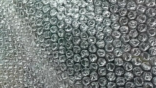 wet bulging plastic with flowing water droplets. white damper plastic wrap texture. plastic with air balls on its surface. used to package fragile items, electronic items or sensitive items.