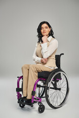 Fototapeta na wymiar beautiful confident disabled woman in pastel clothes sitting in wheelchair and looking at camera